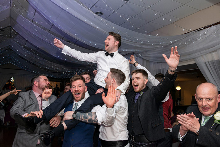  A Groom Being Lifted Above Heads By Male Guests At The Weigh Inn