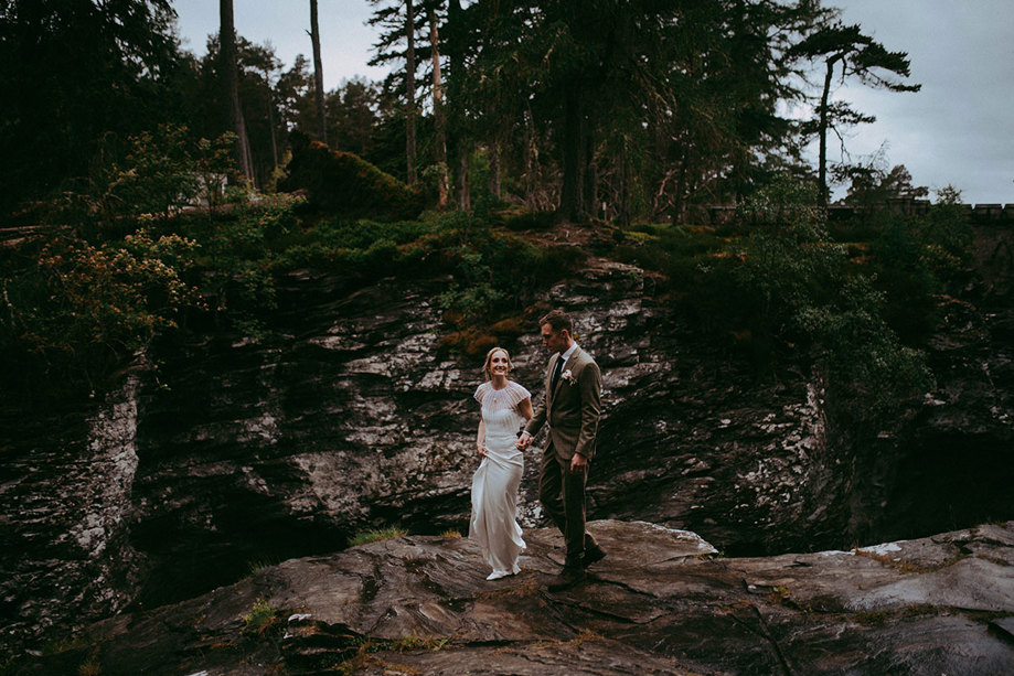 bride and groom walking hand in hand through mar lodge nature reserve