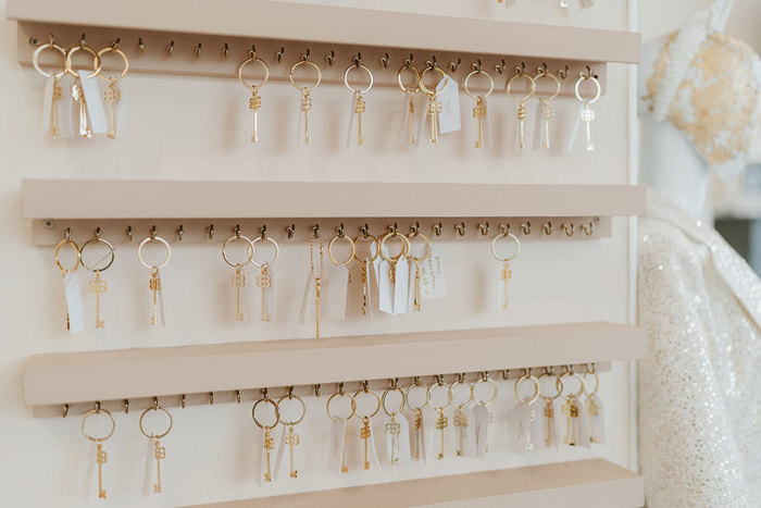 a wall display of gold keys hanging on little keychain loops