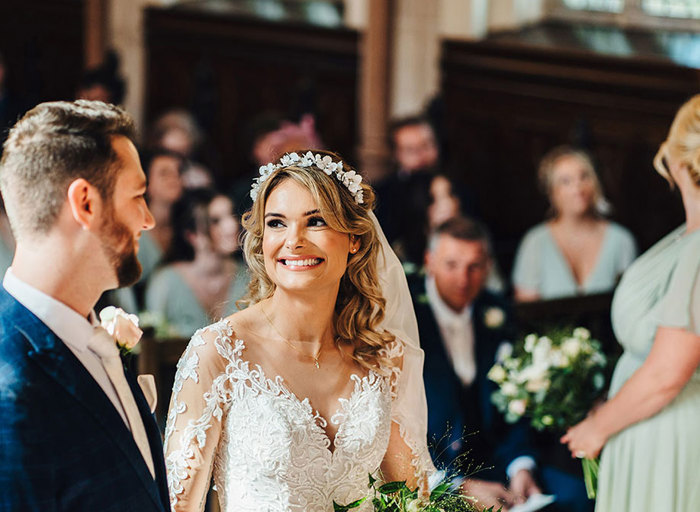 Bride and groom grin at each other at the altar