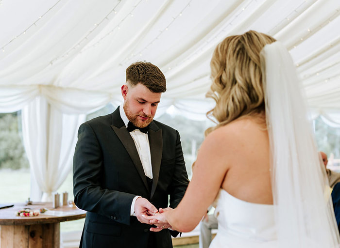 groom putting ring on a bride's finger