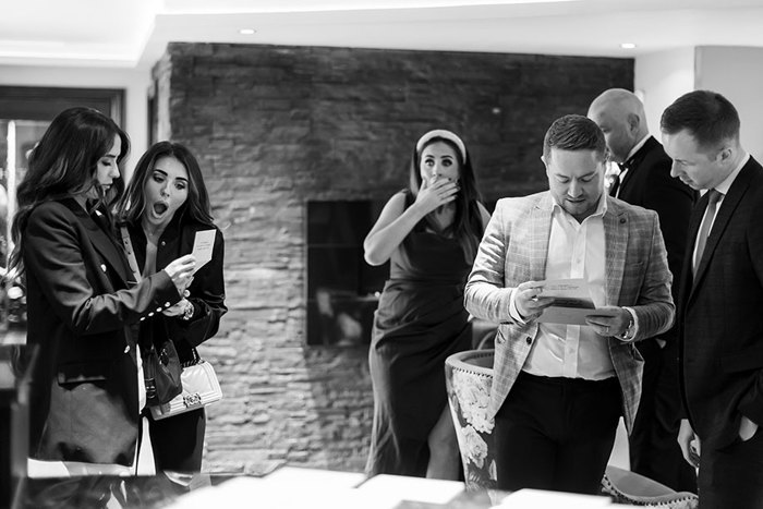 A Group Of People Looking Shocked as they look at cards