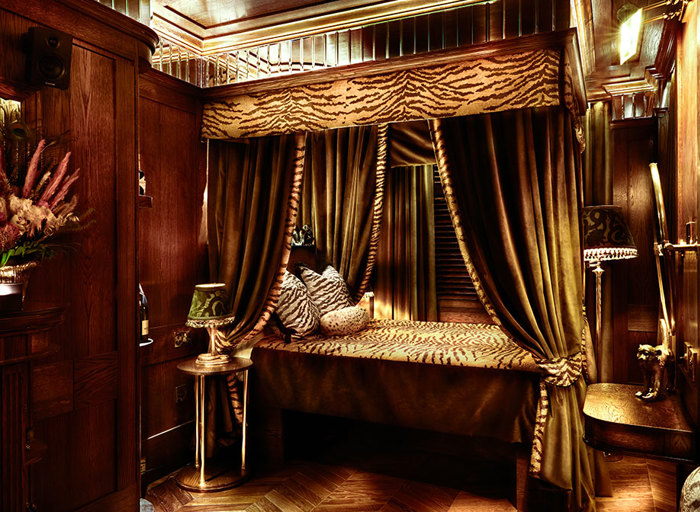 bedroom with four poster bed with curtains and animal print accessories