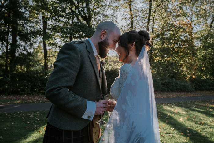 Couple smile at each other with sunlight behind them