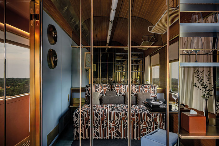 the inside of a luxury train with a geometric bed spread on the bed