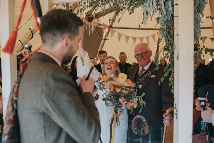 Bride cheers as she walks down the aisle