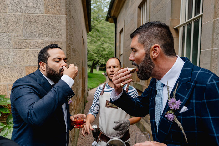 Grooms eat oysters during wedding 