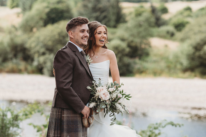 Bride and groom laugh during outdoor couple portraits