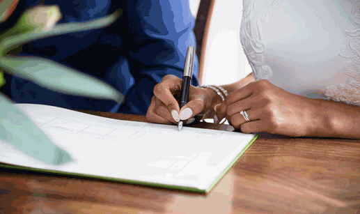 bride and groom sign marriage license after getting married
