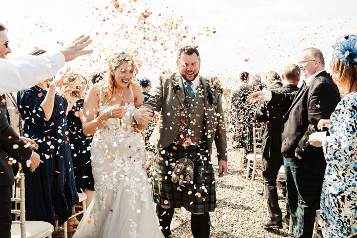 Couple walk through confetti shower