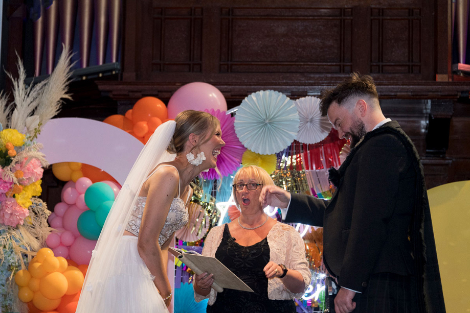 Bride and groom laugh during their wedding ceremony at St Luke's Glasgow