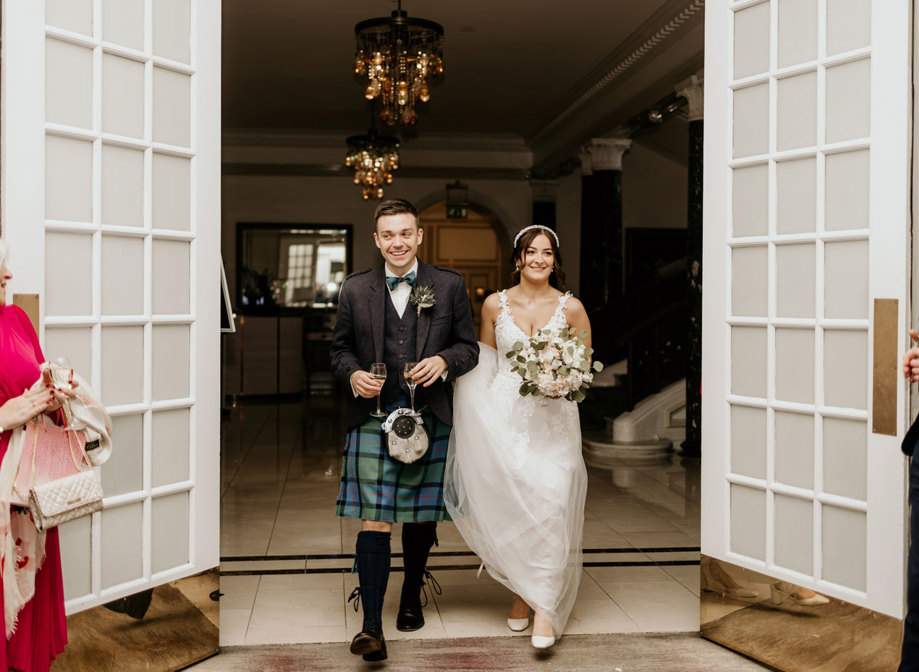 Bride and groom walking into their wedding reception