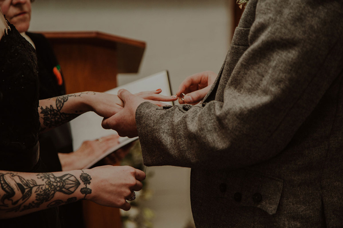 Groom puts ring on the brides finger during the ceremony