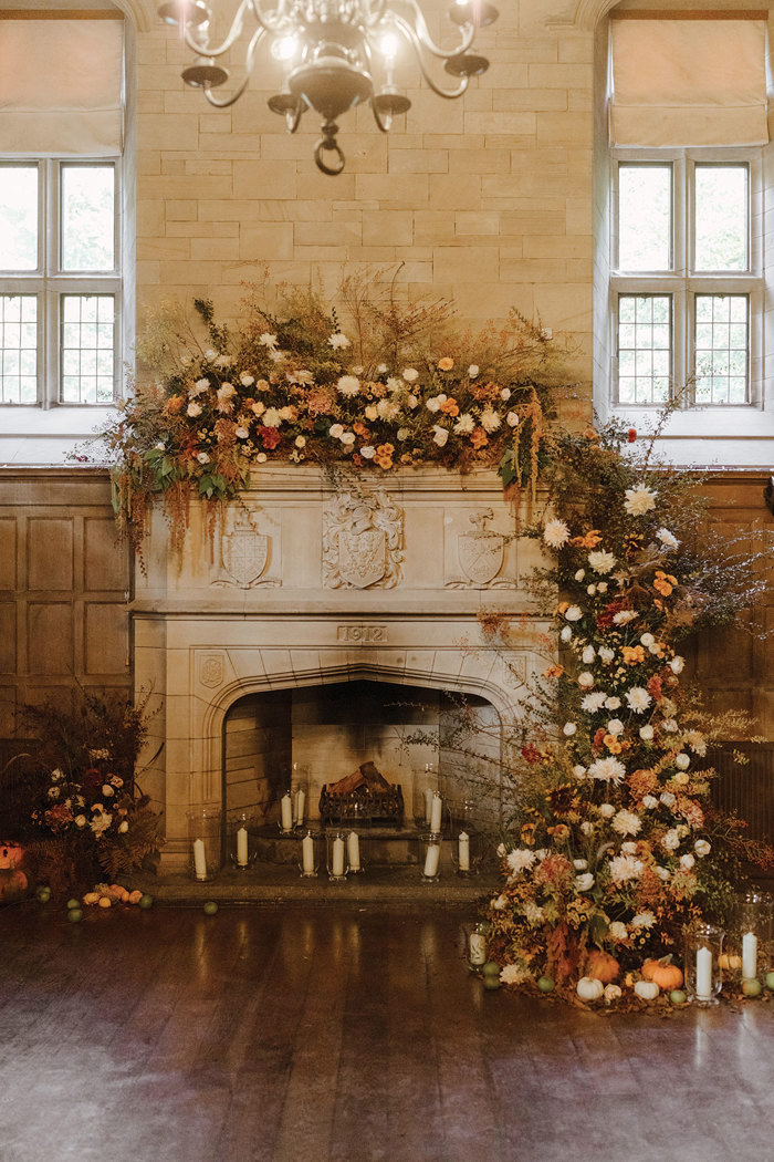 A fireplace with flowers and candles at Achnagairn Castle.