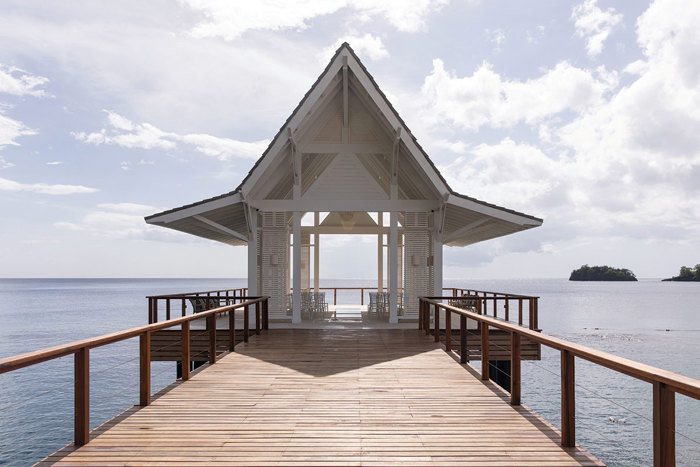 A wooden dock with a white over water chapel structure on it at Sandals St Vincent and Grenadines