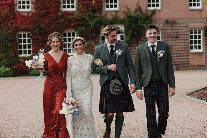 Groom and usher wearing outfits from McCalls walking beside bride and bridesmaid