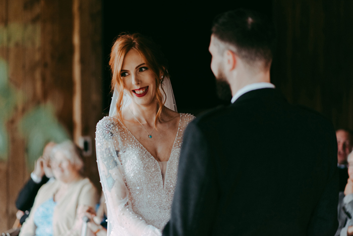 Bride and groom hold hands during the ceremony 