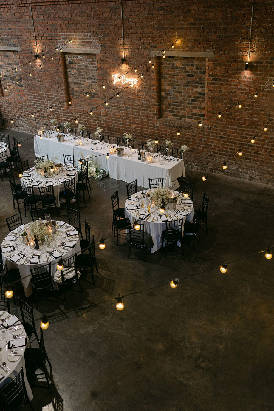 a room with brick walls set with tables and chairs for a wedding