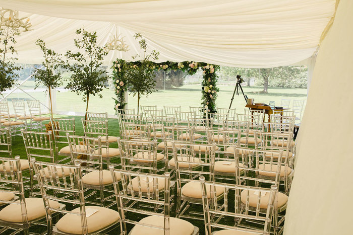 A group of chairs in a tent set for a wedding ceremony at Dunkeld House Hotel.