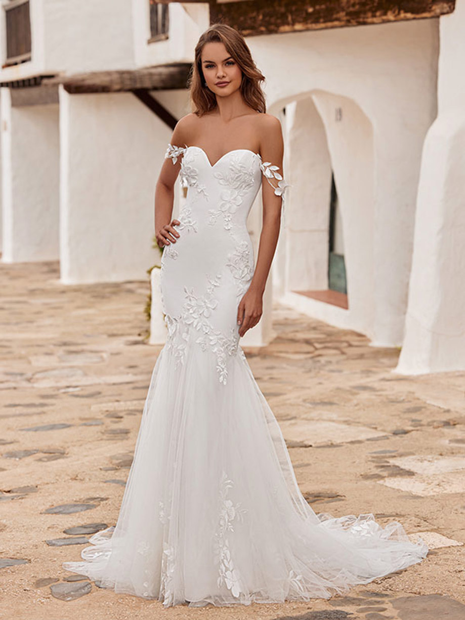 woman wearing a sweetheart neckline wedding dress including 3D floral detailing and decorative shoulder trailing straps