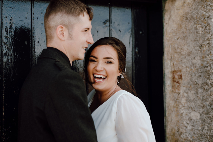 Bride smiles during couple portraits