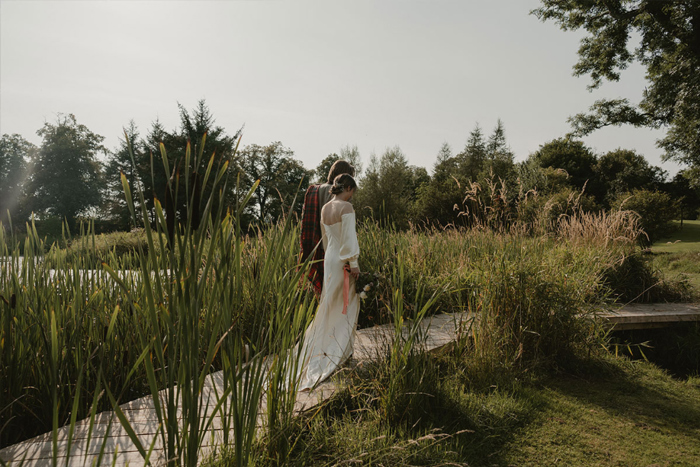 A Bride And Groom Walking In The Grounds At Hartree Estates