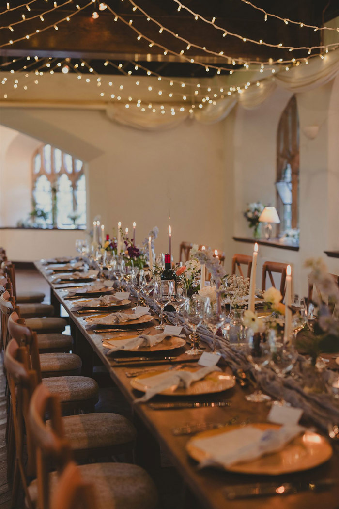 A long table set with candles and flowers.