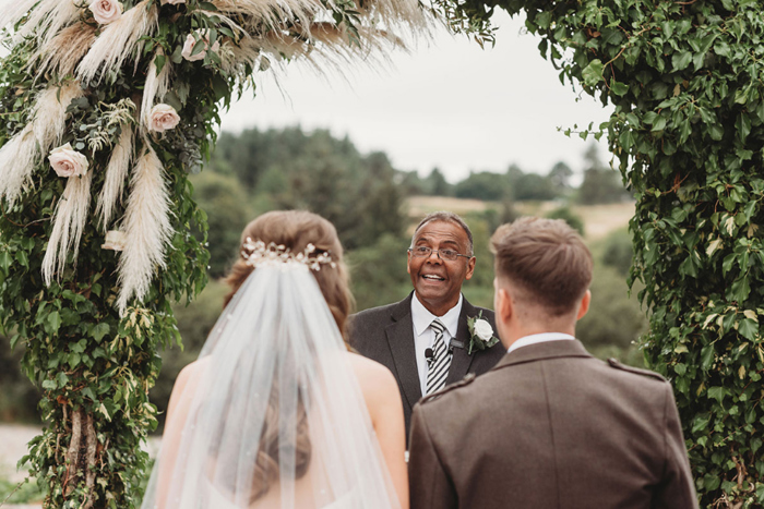 Back of bride and groom's heads during wedding ceremony at Maryculter House