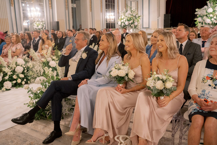 Guests smile during wedding ceremony