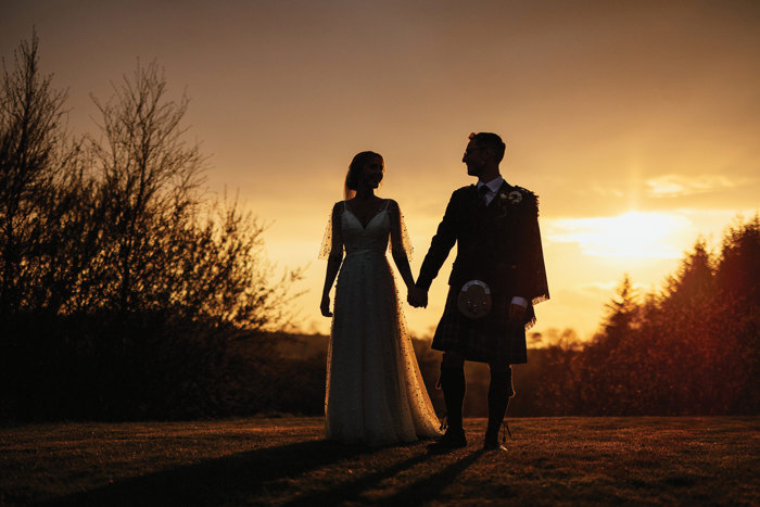 bride and groom pose together at dusk