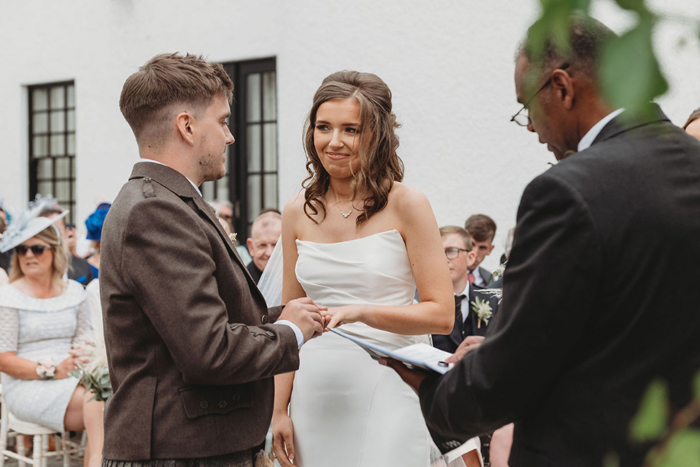 Bride and groom hold hands during the ceremony 