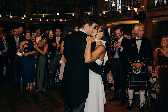 a bride and groom kissing in the ballroom at Achnagairn Castle