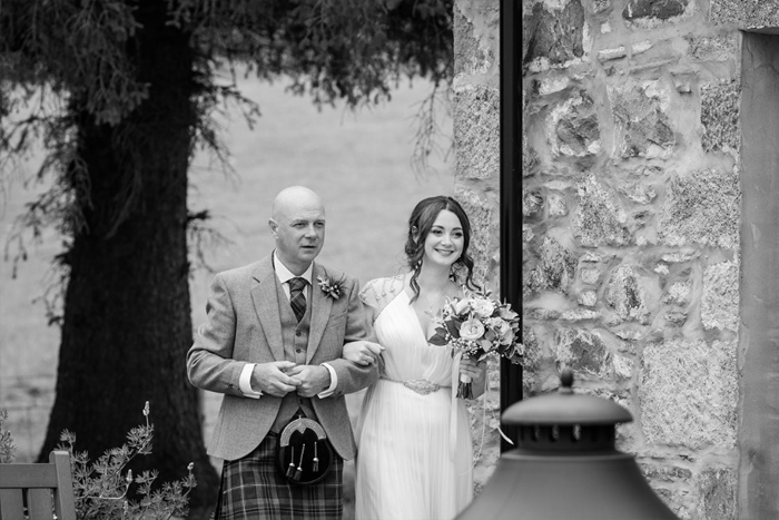 Black And White Image Of A Bride Walking On The Arm Of A Man