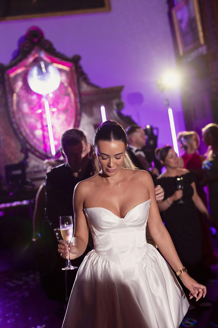 a bride wearing a short wedding dress with peaked bodice and basque waistline.