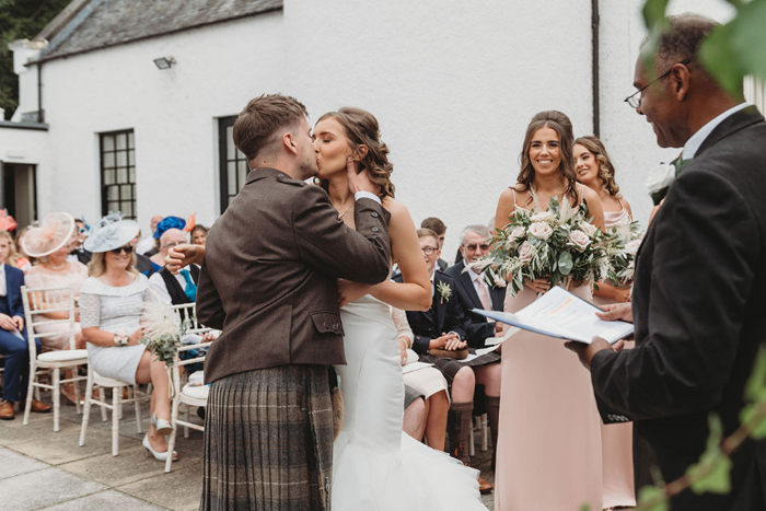 Happy couple kiss during their ceremony