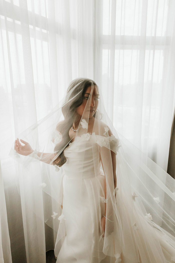 bride with flower applique veil at signet library at window