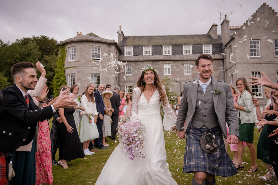 A Bride And Groom Being Showered In Confetti Outside Raemoir House