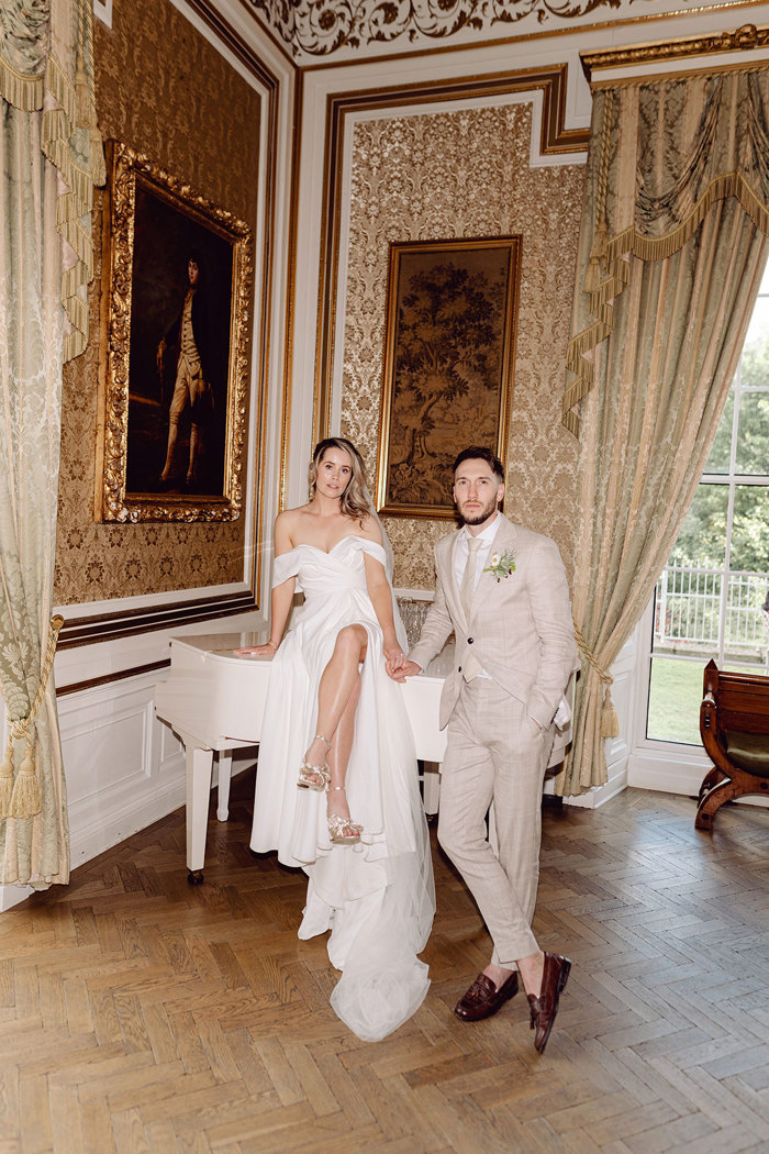 couple sit on piano at drumtochty castle after getting married