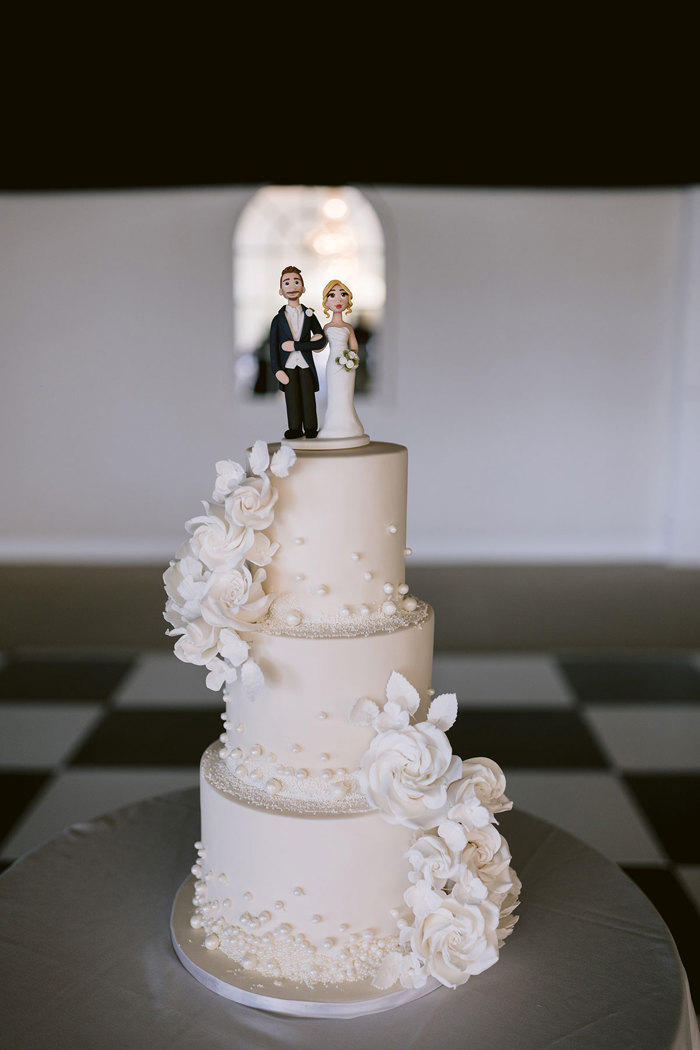 A wedding cake with a couple figurines on top.