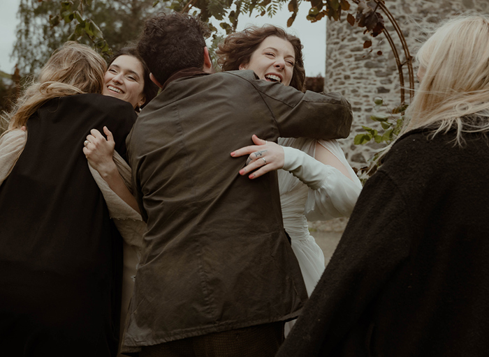 wedding guests hugging two brides