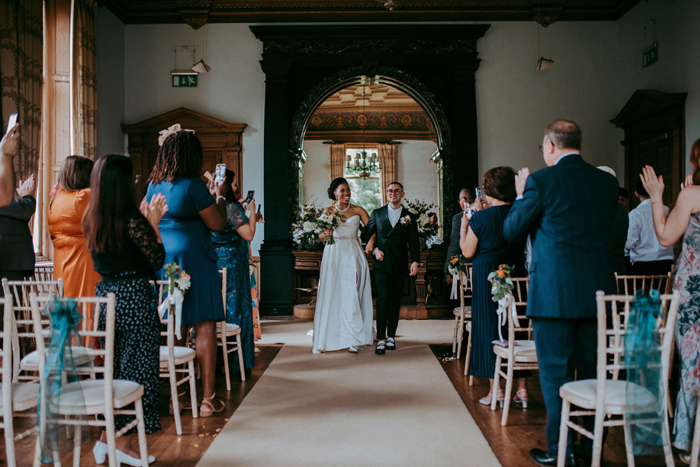 Bride and groom walk back up the aisle as newlyweds