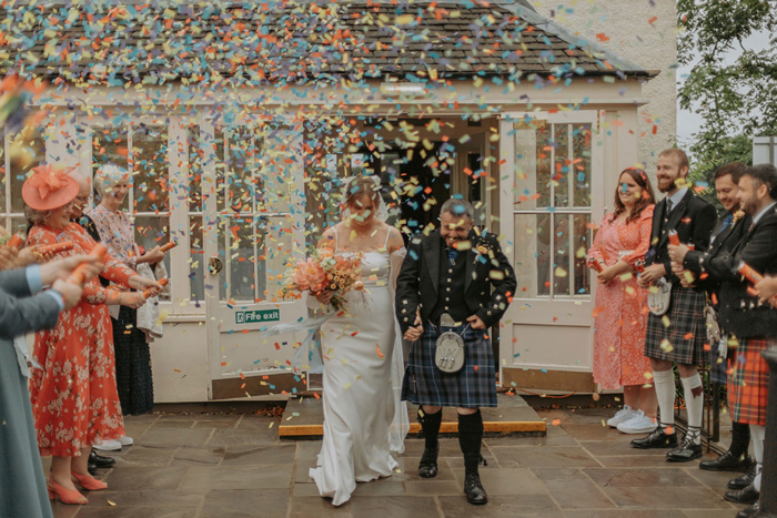 Couple walk through confetti shower