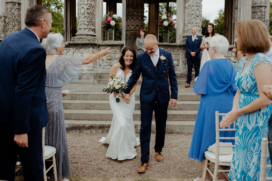 Bride and groom walk through guests lining the aisle