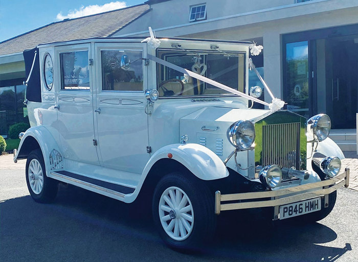 A white vintage car parked in the sun 