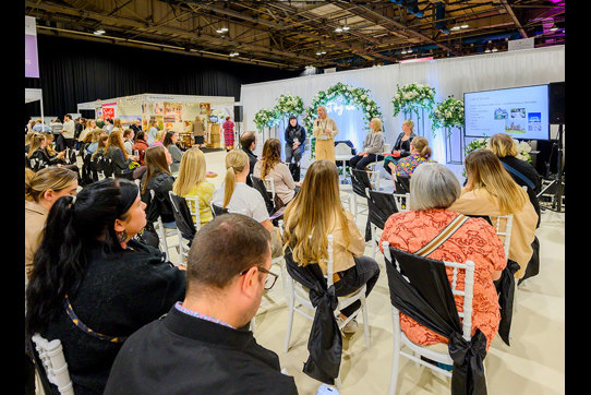 An audience watching a talk on stage with a presentation 