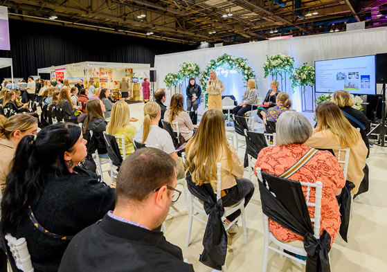 An audience watching a talk on stage with a presentation 