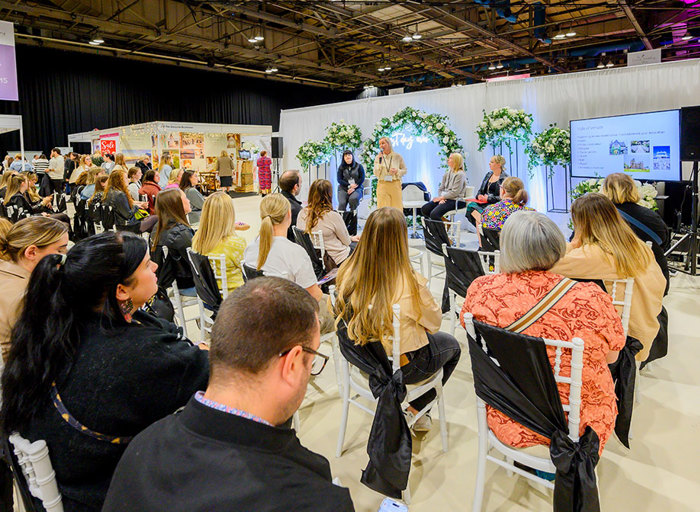 An audience watching a talk on stage with a presentation 