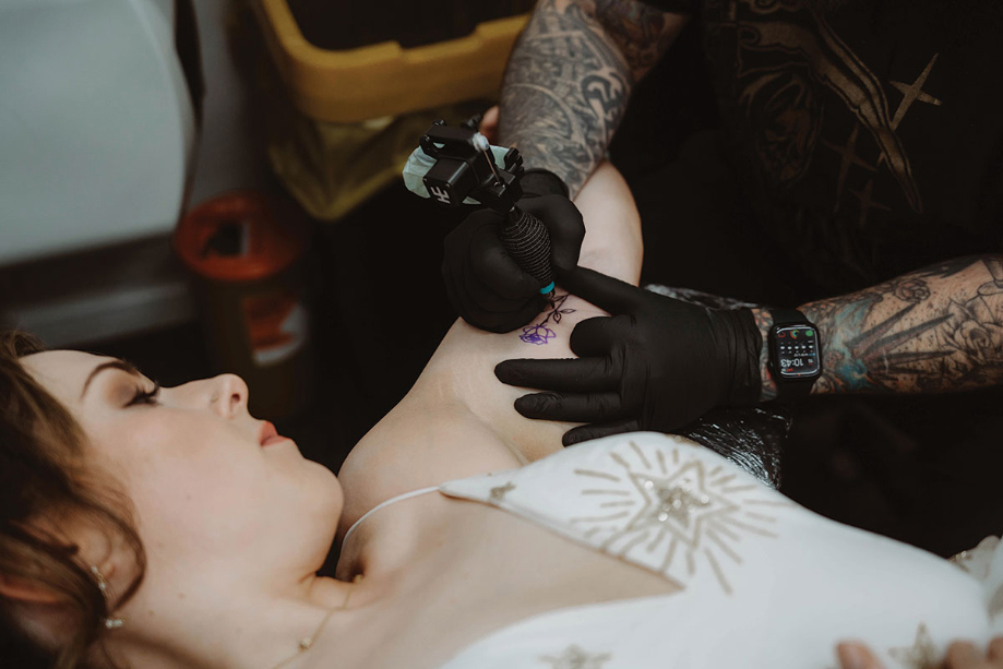 Bride getting rose tattoo on wedding morning