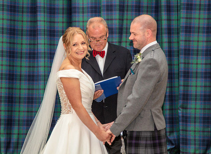 A bride and groom holding hands during their wedding ceremony