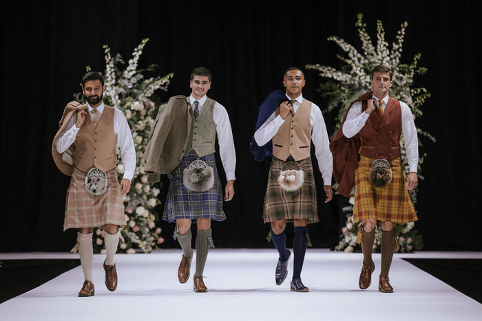 four men in muted but colourful kilt outfits from Kilts 4 U on the catwalk at the Scottish Wedding Show